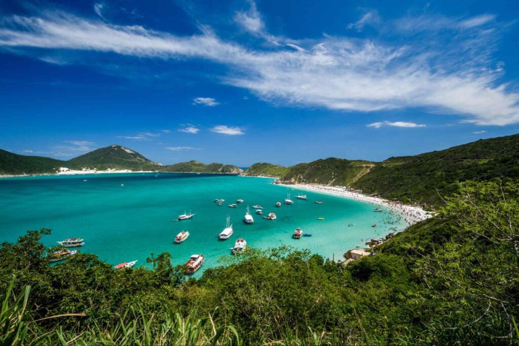 Orla da Praia de Arraial do Cabo. O mar azul esverdeado entra em contraste com os barcos brancos ancorados perto da areia