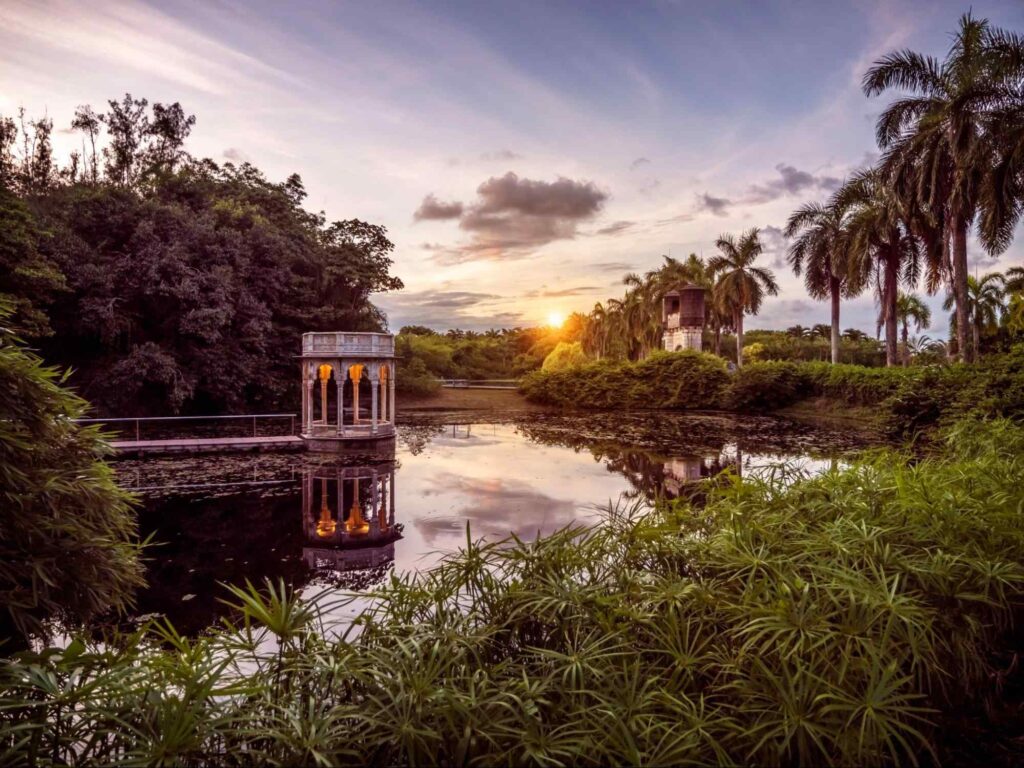 Parte do Instituto Ricardo Brennand, em Recife. A área aberta tem um lago com um coreto, cercado por vegetação abundante.