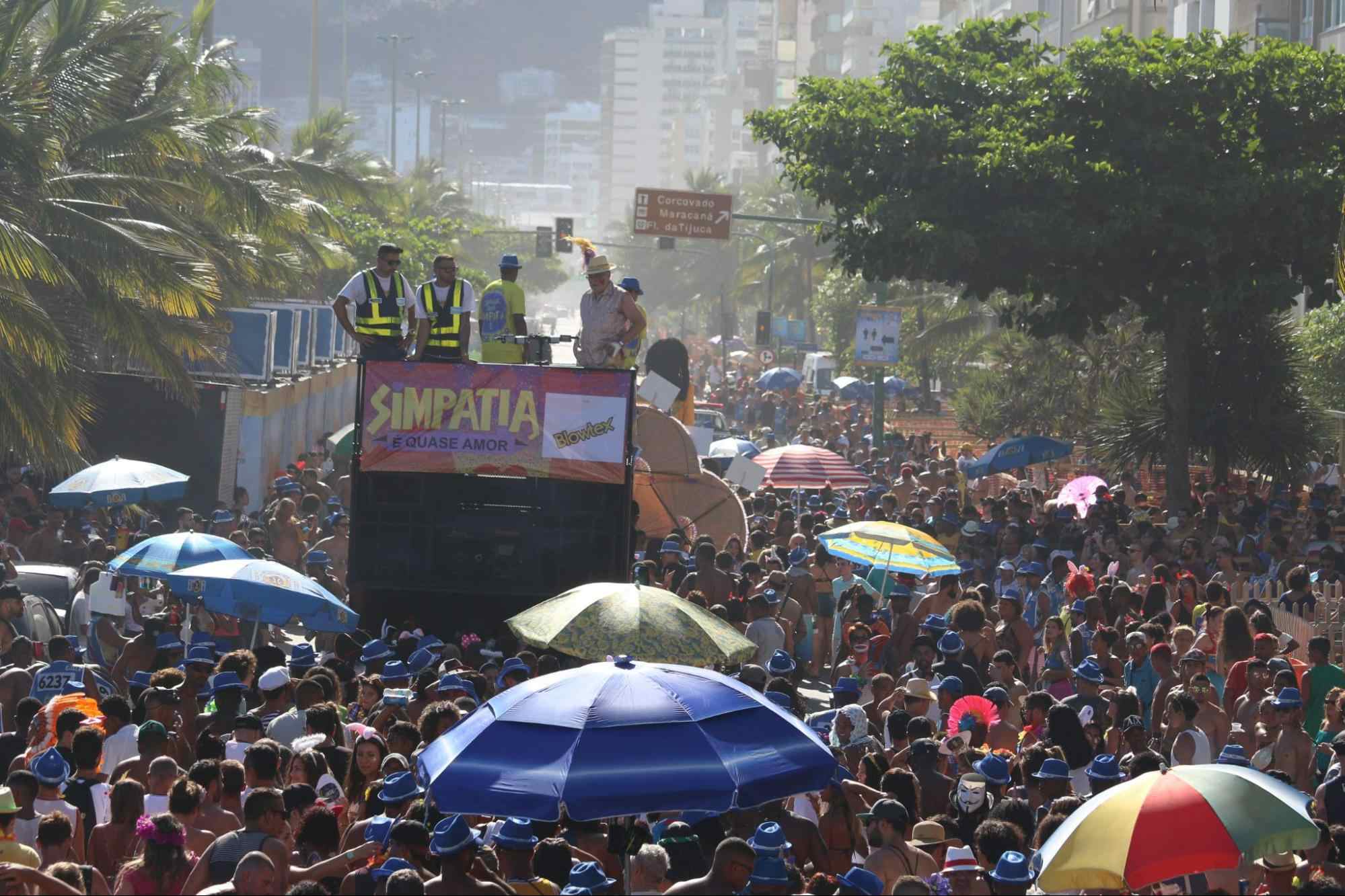 Carnaval do Rio de Janeiro, com uma das avenidas repleta de foliões que seguem um trio elétrico