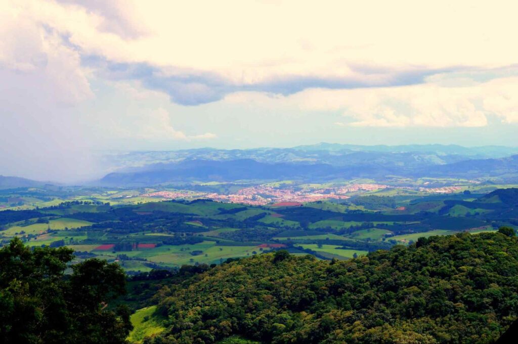 Paisagem montanhosa com a cidade de Ouro Fino MG centralizada ao redor da natureza.