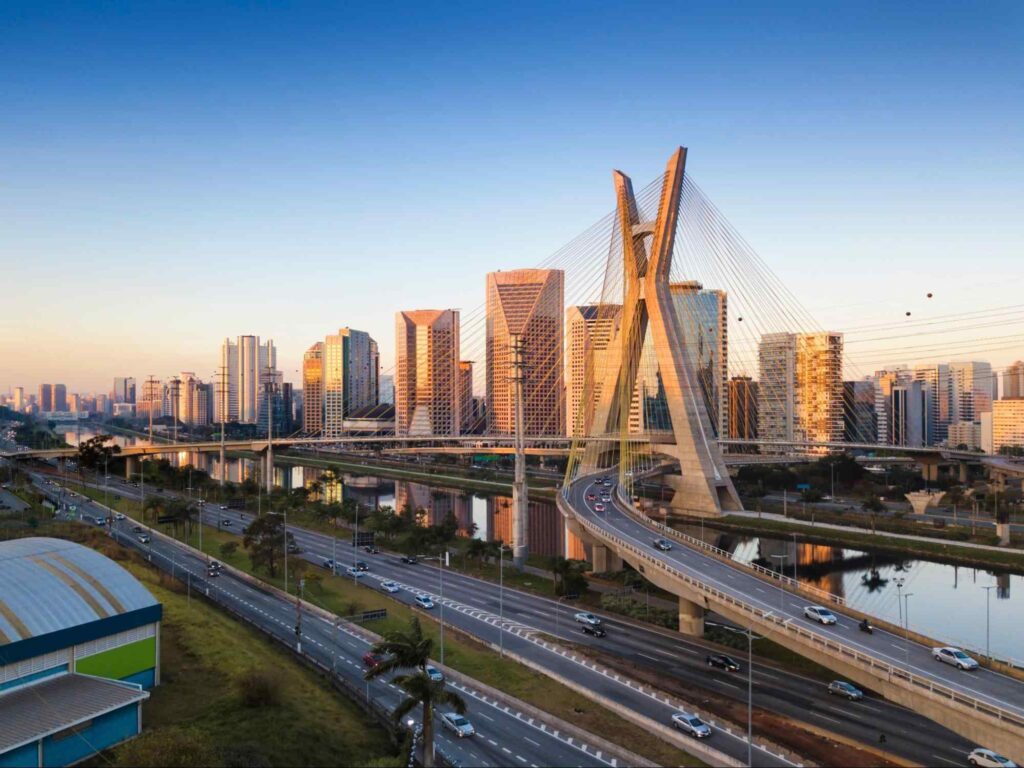 Imagem panorâmica de São Paulo, com a famosa Ponte Estaiada Octavio Frias de Oliveira e os prédios da cidade ao fundo.