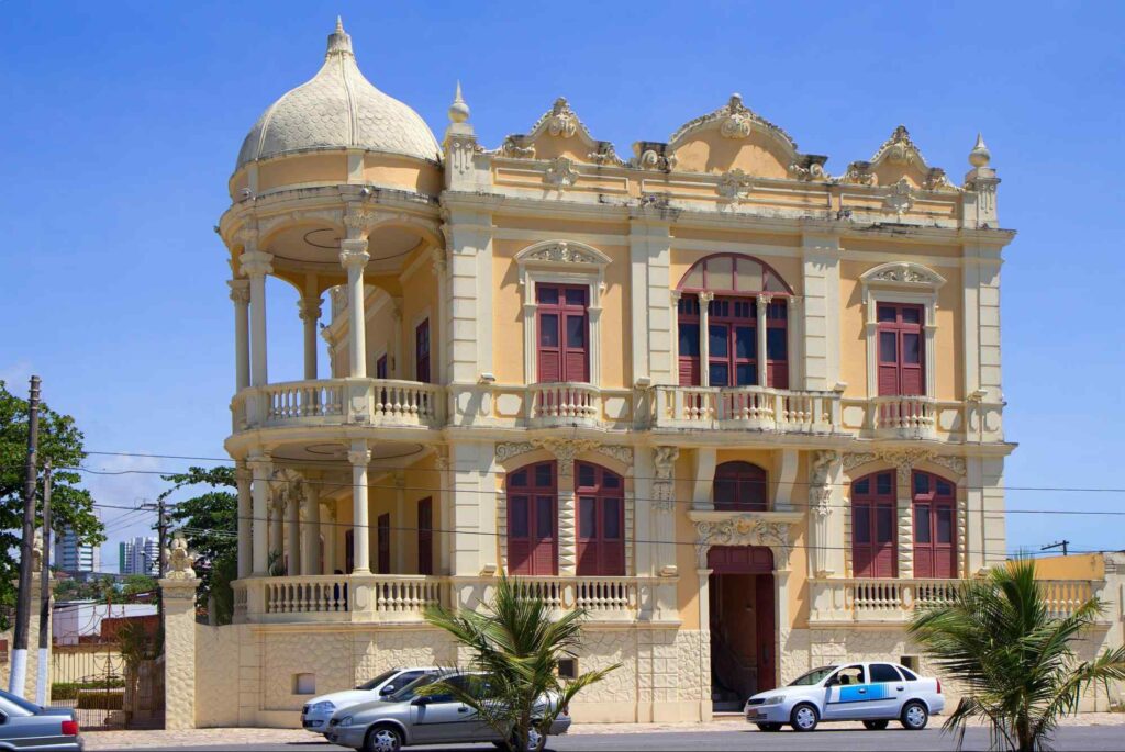 Fachada colonial do Museu Théo Brandão, com janelas marrons e uma abóbada na sacada princial, em Maceió