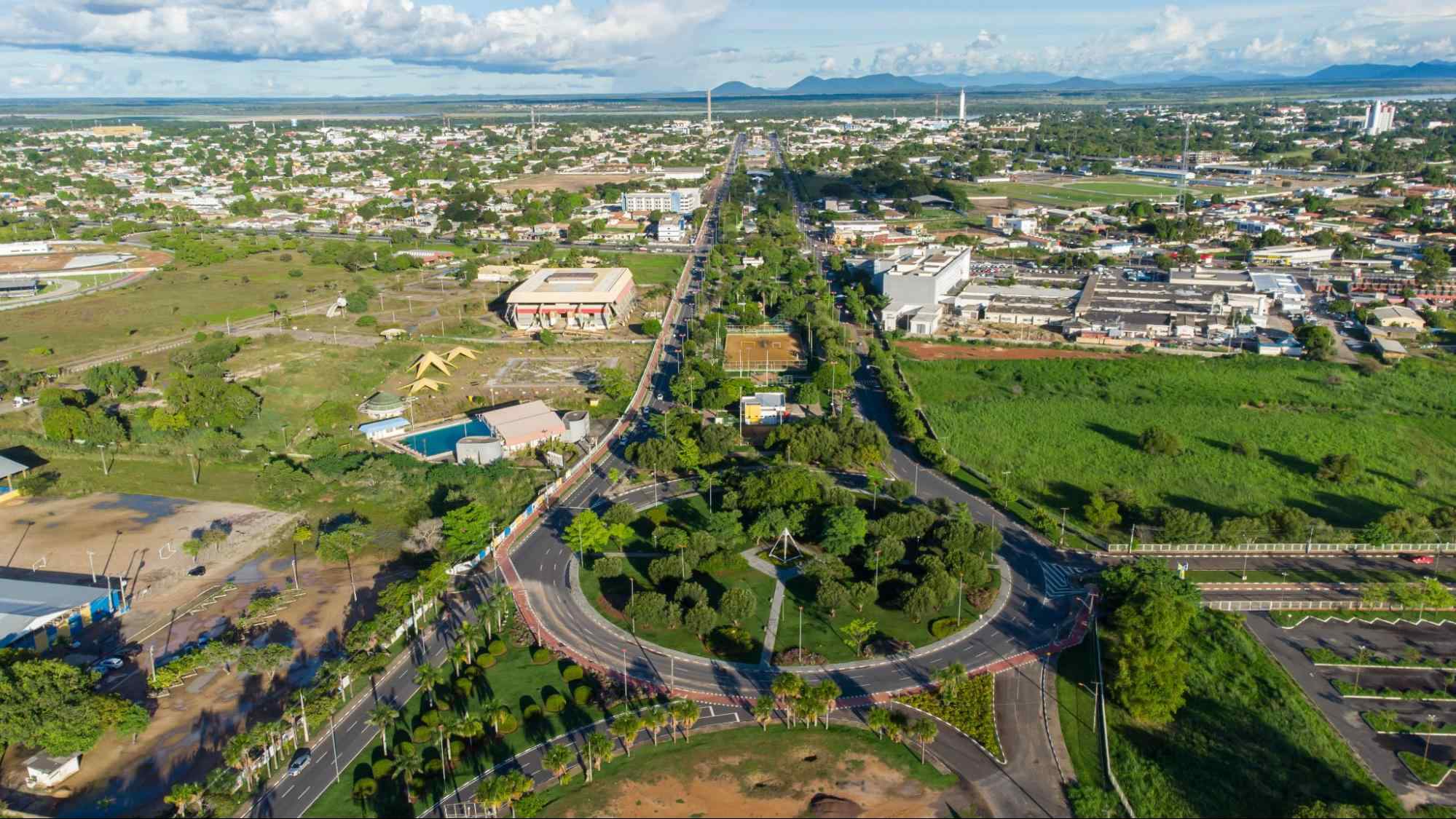 Vista aérea da cidade de Boa Vista RR. Rotatória centralizada na imagem, com diversas árvores em seu centro e com as ruas ao redor também repletas de área verde