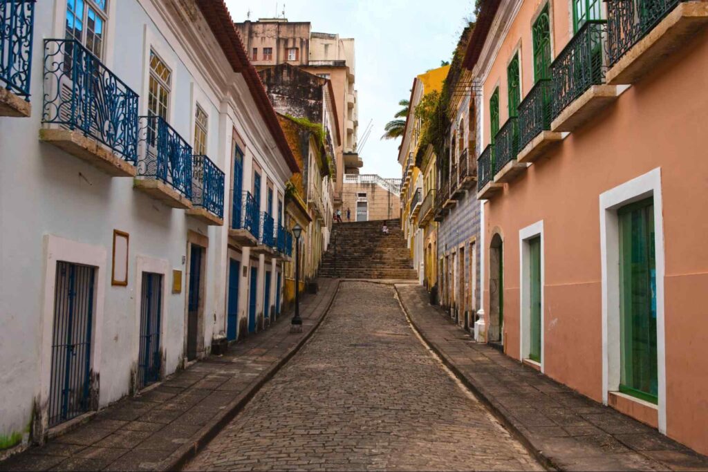 Rua do Centro Histórico de São Luís. A estreita via revestida em paralelepípedos tem casarões antigos dos dois lados e uma escadaria ao final