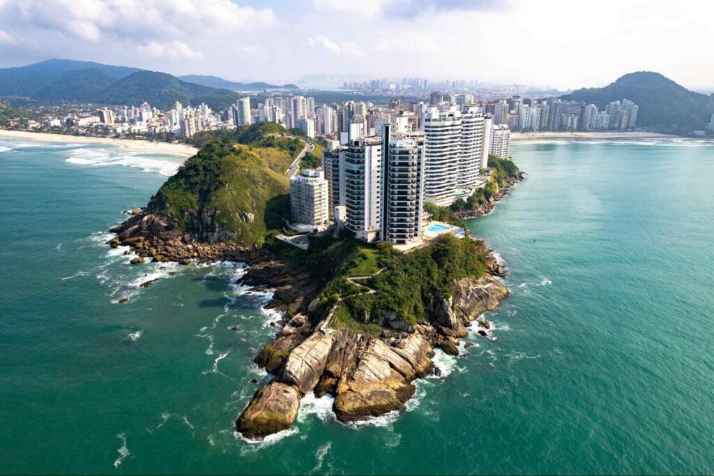 Vista aérea de Guarujá.Grande montanha rochosa na água do mar, com prédios em seu topo