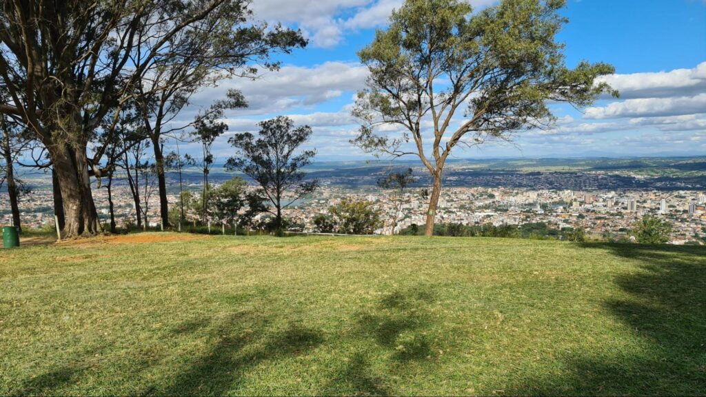 Mirante da Serra de Santa Helena em Sete Lagoas MG. Gramado no topo da serra com algumas árvores, com vista para a cidade.