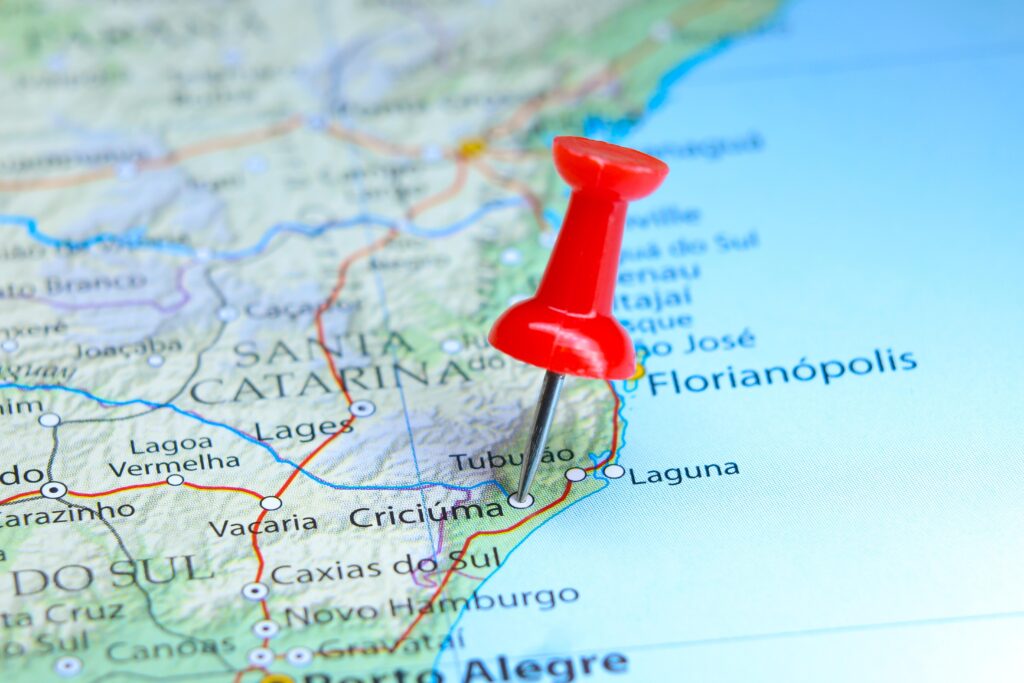 Imagem de um mapa de Santa Catarina com um pin vermelho marcando a localização de Criciúma