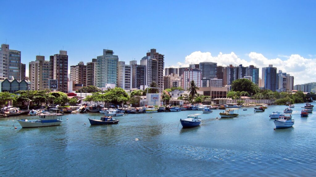 Foto panorâmica da cidade de Vitória, com barcos ancorados no mar próximos da praia