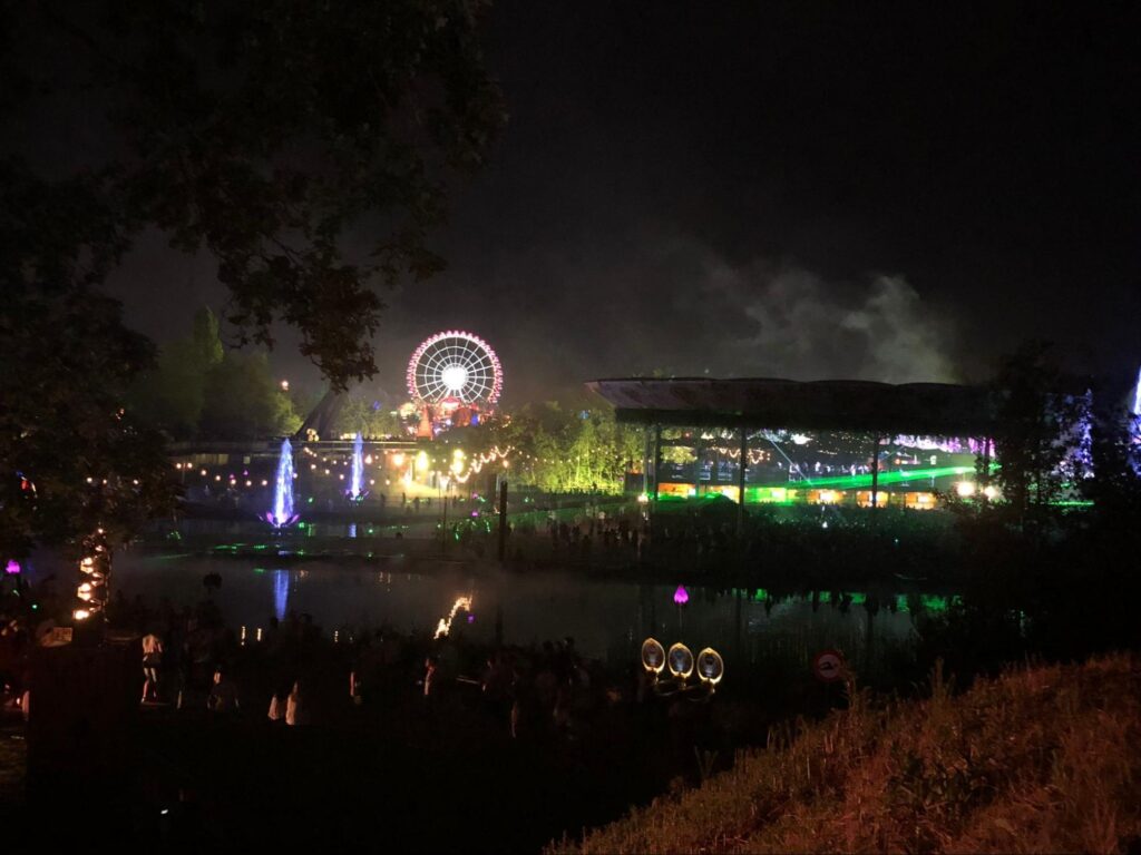 Paisagem do Tomorrowland 2018, em Boom, na Bélgica. Com o palco ao fundo, luzes e a roda gigante do parque