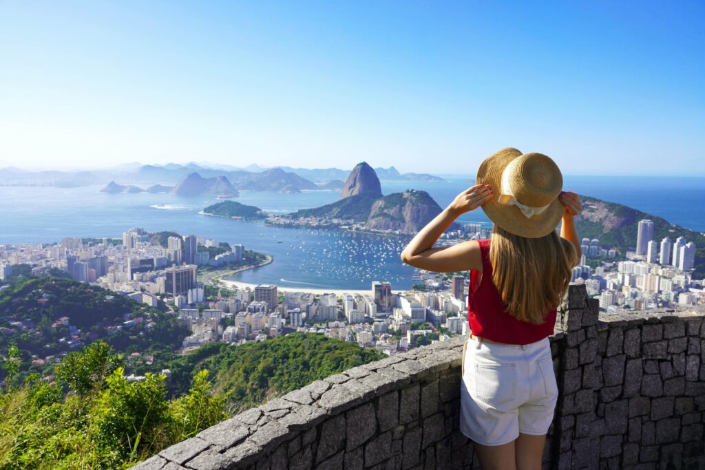 Mulher de costas em um mirante com a cidade do Rio de Janeiro ao fundo