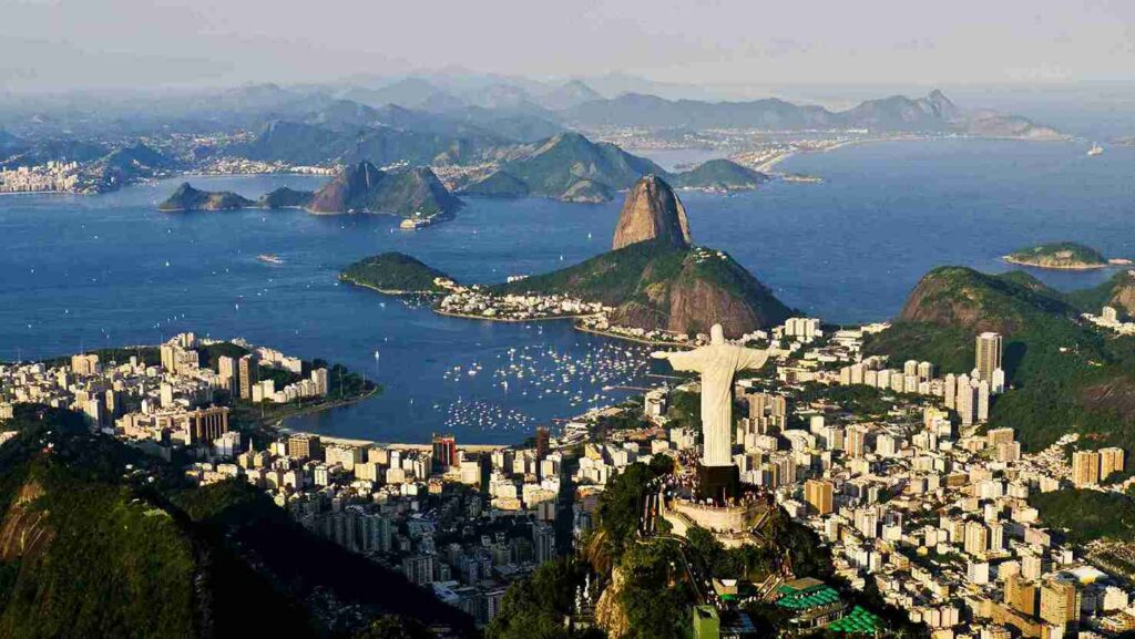 Calçadão de pedras portuguesas e mar azul, destino acessível de ônibus no Rio de Janeiro.